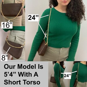 May include: A brown leather shoulder bag with a gold chain strap. The bag is 8 inches tall and 16 inches wide. The strap is 24 inches long. The model is 5'4" tall and has a short torso.