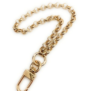 May include: A gold chain with a lobster clasp. The chain is made of small, round links.