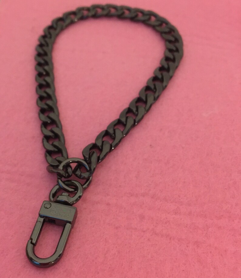 May include: A black metal chain with a hook clasp. The chain is about 10 inches long and has a curb link design.
