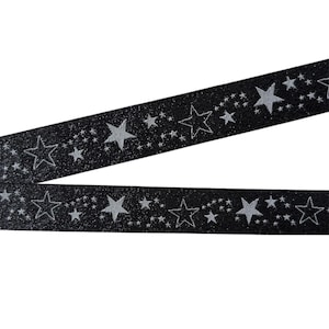 May include: Black ribbon with silver glitter and silver stars. The ribbon has a repeating pattern of large and small stars.