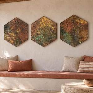 May include: Three hexagonal wall art pieces featuring a textured, mottled finish in shades of copper, bronze, rust, and oxidized green. The panels are arranged horizontally in a row, displaying a metallic, weathered appearance with varied color blending.