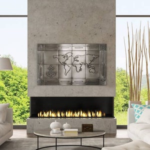 May include: A modern living room with white sofas, a gray rug, and a black coffee table. The room features an orange accent wall, large windows, and a fireplace with a metal world map art piece above it. A white chair is in the foreground.