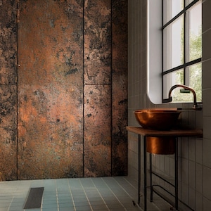 May include: A bathroom featuring a copper sink and tap, set against textured copper-coloured wall panels. The sink rests on a wooden stand with a lower copper basin. A window with a black frame is visible.