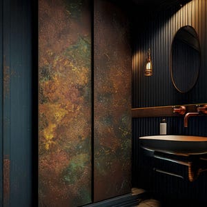 May include: A bathroom interior featuring a dark color palette with a copper-toned sink and fixtures. The walls are a deep blue, with a textured, rust-colored accent wall. An oval mirror and a decorative light fixture complete the scene.