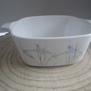 May include: White square baking dish with a floral design featuring blue and green irises.