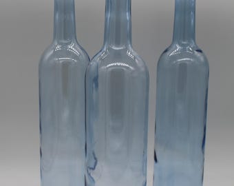 Enchanting set of three glass vases made from light blue vintage bottles