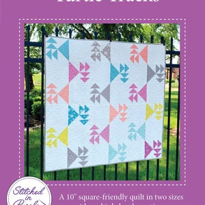 May include: A quilt pattern called "Turtle Tracks" featuring a 10-inch square-friendly quilt in two sizes with multiple border options. The quilt is made with a white background and colorful geometric shapes.