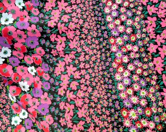 Printed fabric with floral patterns. Sewing fabric black background, colorful flowers. Clothing fabric.