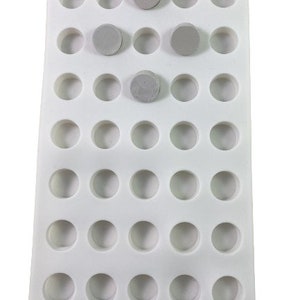 May include: White silicone mold with 49 round cavities, ideal for making small candies, chocolates, or other treats.