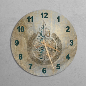 May include: A round wall clock with a gold and blue background featuring Arabic calligraphy. The clock face has black numbers and a gold hour and minute hand.
