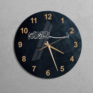 May include: A black clock with gold Arabic numerals and hands. The clock face has a white Arabic calligraphy inscription that reads "Allah is the Most Merciful".