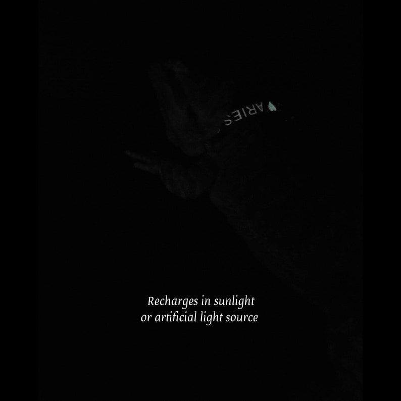 K&ouml;nnte beinhalten: Ein dunkles, leuchtendes Halsband mit dem Text ARIES und einem Herzsymbol. Der Text Recharges in sunlight or artificial light source ist am unteren Bildrand sichtbar und weist auf die Leuchteigenschaften des Halsbanddesigns hin.