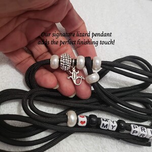 May include: Black paracord leash with white beads, a silver lizard charm, and black and white letter beads that spell "MY MY PR PR".