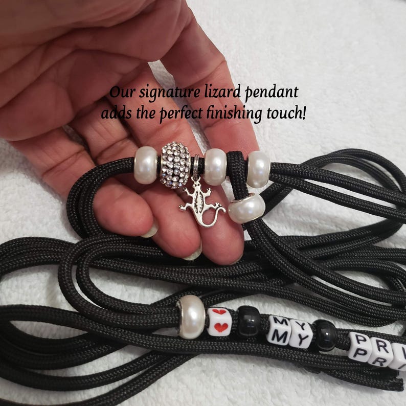 May include: Black paracord leash with white beads, a silver lizard charm, and black and white letter beads that spell "MY MY PR PR".
