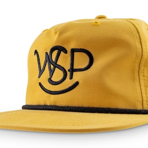 Peut inclure: Une casquette de baseball jaune avec une bordure en corde noire et un logo brodé noir qui dit "WSP" avec un smiley en dessous.