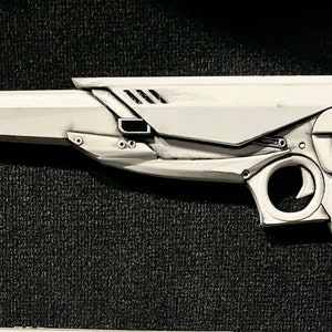 3D printed ray gun prop in white with black grips, shown from a side profile. Set against a black textured background to highlight the clean design. Perfect for MCR fans, collectors, and those seeking a unique ray gun replica.