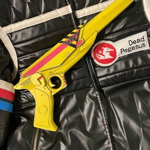 3D printed ray gun prop painted to match Party Poison’s weapon from Danger Days music videos. Side profile view on top of a replica Party Poison cosplay jacket. Perfect for MCR fans, collectors, and cosplay enthusiasts looking for accurate props.