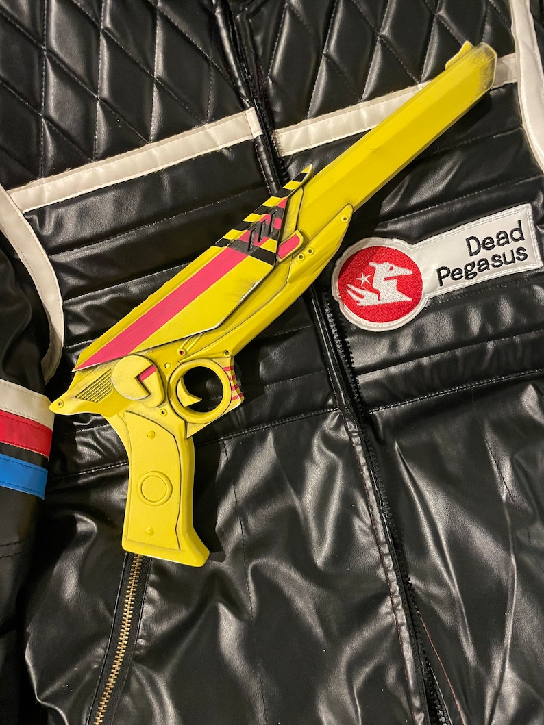3D printed ray gun prop painted to match Party Poison’s weapon from Danger Days music videos. Side profile view on top of a replica Party Poison cosplay jacket. Perfect for MCR fans, collectors, and cosplay enthusiasts looking for accurate props.