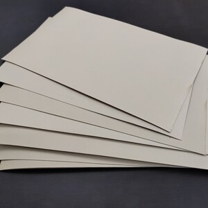 May include: A stack of eight off-white cardstock sheets.