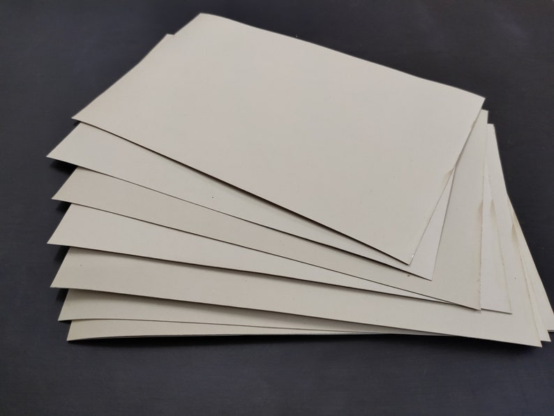 May include: A stack of eight off-white cardstock sheets.