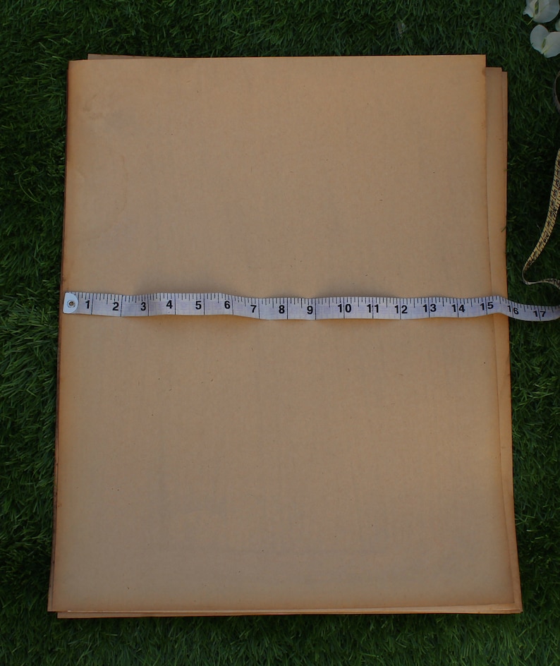 Op de afbeelding: Een stapel bruin papier met een meetlint eroverheen. Het lint meet 43 cm.