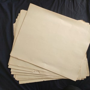 May include: A stack of blank, off-white paper sheets. The paper is slightly yellowed and has a rough texture.
