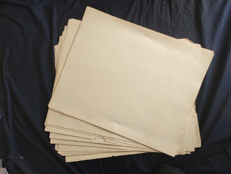 May include: A stack of blank, off-white paper sheets. The paper is slightly yellowed and has a rough texture.