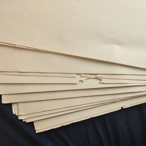 May include: A stack of off-white paper sheets with slightly uneven edges.