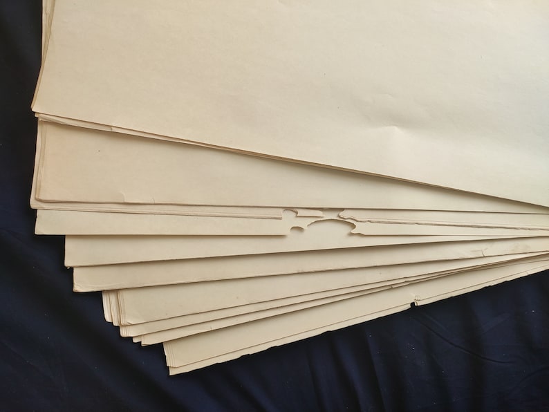 May include: A stack of off-white paper sheets with slightly uneven edges.