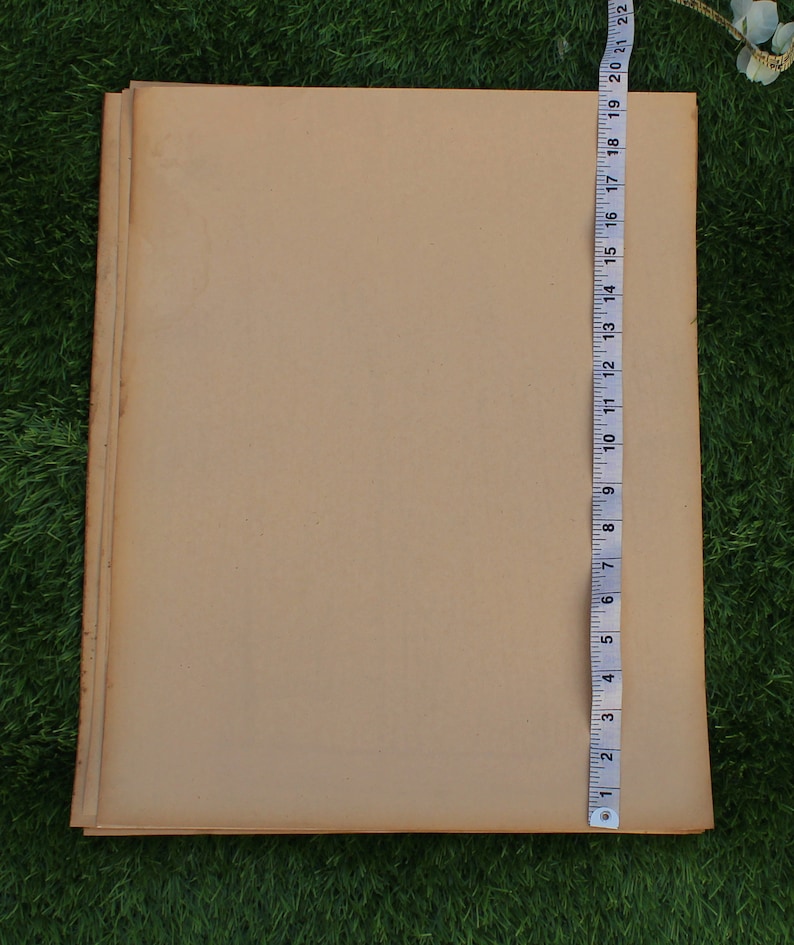 Op de afbeelding: Een stapel bruine papieren vellen met een meetlint langs de rechterrand. De tape meet tot 56 cm.