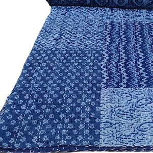 May include: A blue kantha quilt with a patchwork design featuring various geometric patterns. The quilt is made of cotton and is hand-stitched.