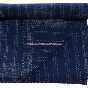 May include: A dark blue kantha quilt with white stitching in a geometric pattern. The quilt is folded and rolled up.