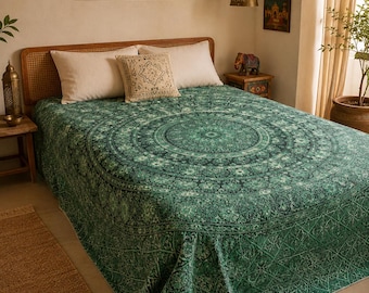 May include: A bedspread featuring a dark green and teal circular mandala pattern with intricate floral and geometric details. The fabric covers the mattress and hangs over the sides, displaying a repeating motif that radiates from the center.