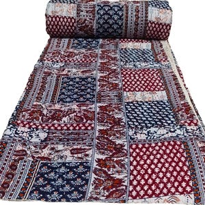 Peut inclure: Une courtepointe patchwork avec une variété de motifs floraux et géométriques dans des tons de rouge, bleu et blanc.
