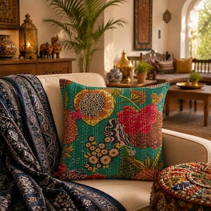 May include: A square throw pillow featuring a vibrant teal background with a multi-colored floral pattern in shades of pink, orange, yellow, and brown. The fabric displays visible white running stitch details throughout the surface texture.