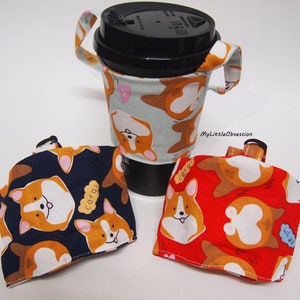 Puede incluir: Tres fundas reutilizables para tazas de café con un estampado de perro corgi. Una funda está en una taza de café negra. Las fundas son de color azul marino, rojo y azul claro con caras de perro corgi y la palabra "corgi".