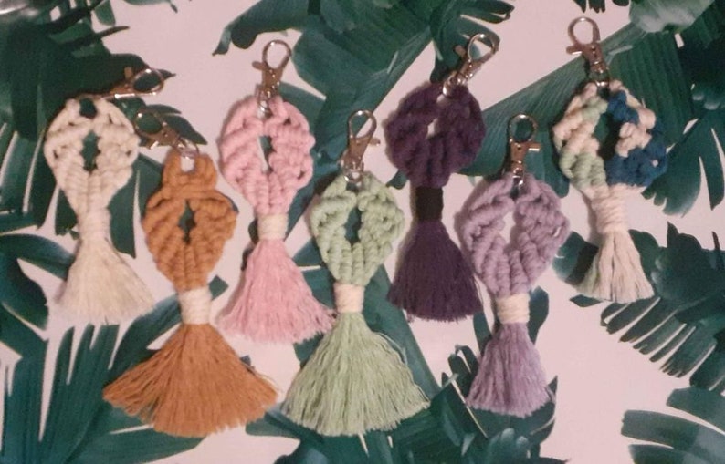 May include: Seven colorful macrame keychains with tassels. The keychains are made with different colored yarn and feature a variety of patterns.
