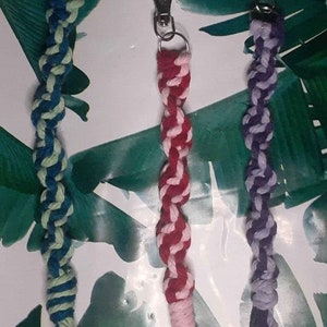 May include: Three colorful braided keychains with silver key rings. The keychains are made of a thick, twisted cord. The colors are blue and green, pink and red, and purple and white.