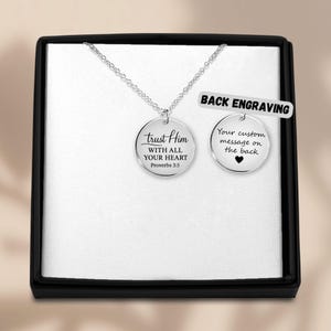 Könnte beinhalten: Eine silberfarbene Halskette mit einem runden Anhänger. Der Anhänger trägt die Inschrift "trust Him WITH ALL YOUR HEART Proverbs 3:5". Ein zweiter Anhänger zeigt "Your custom message on the back" mit einem Herzsymbol.