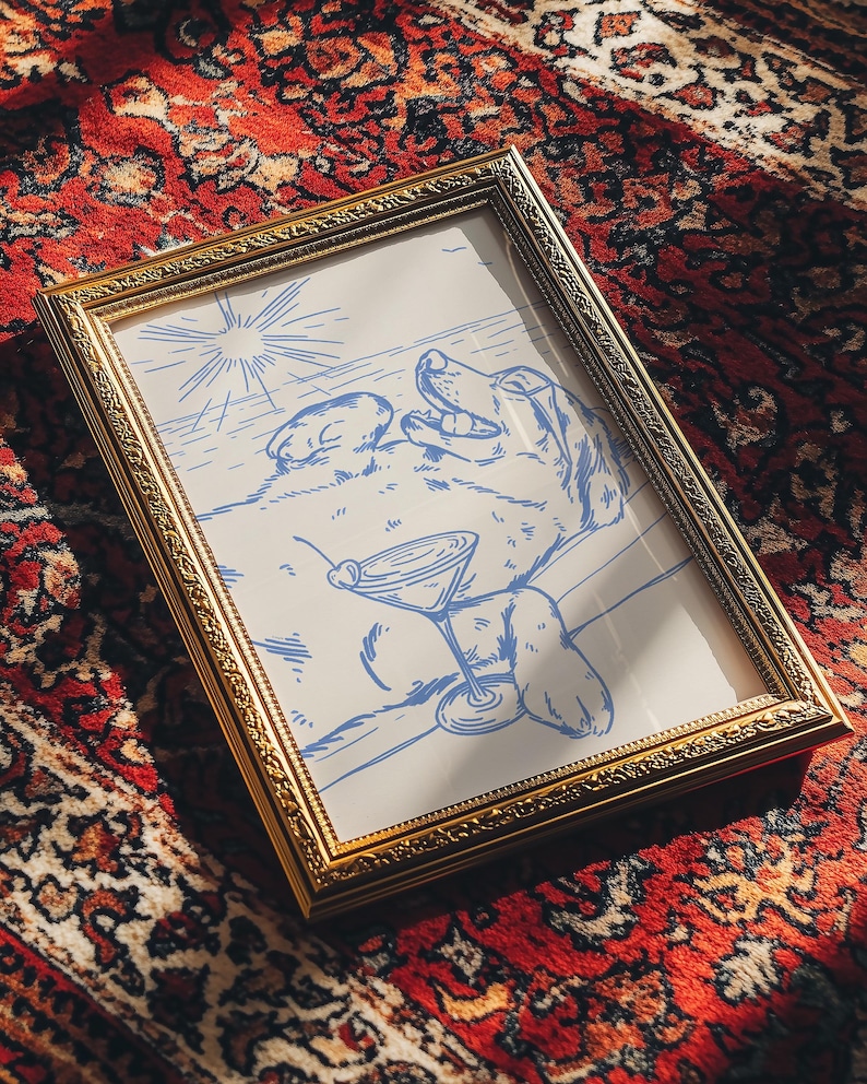 May include: A framed art print featuring a blue line drawing of a dog relaxing with a martini. The artwork is in a gold-colored ornate frame, set against a red patterned rug.