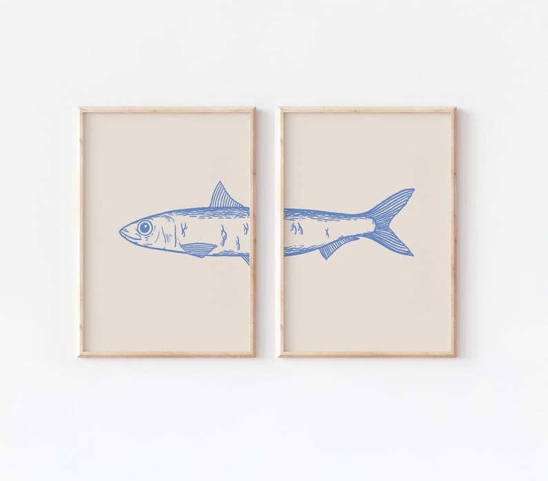 May include: Two framed prints of a blue line drawing of a fish on a beige background. The fish is split between the two frames.