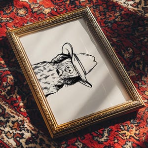 Puede incluir: Un dibujo en blanco y negro de un perro con un sombrero de vaquero. El dibujo est&aacute; enmarcado en un marco dorado y est&aacute; sobre una alfombra de patr&oacute;n rojo y blanco.