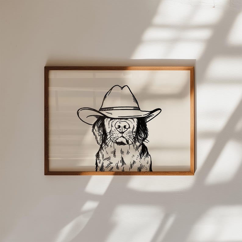 Puede incluir: Una ilustraci&oacute;n en blanco y negro de un perro con un sombrero de vaquero. El perro est&aacute; mirando directamente al espectador. La ilustraci&oacute;n est&aacute; enmarcada en un marco de madera marr&oacute;n claro.