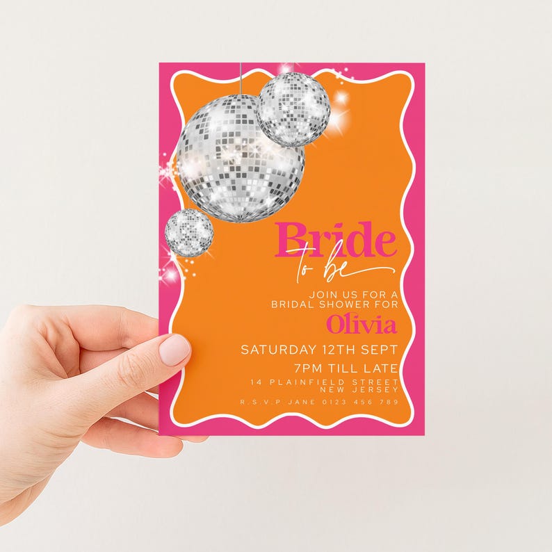 A hand holding a colorful invitation card with a disco ball design and text inviting people to a bridal shower.