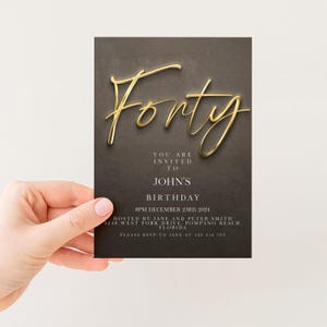 a person holding a birthday invitation card with the word "Fifty" written on it.
