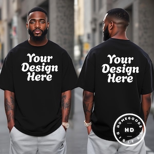 May include: Black oversized t-shirt with the text "Your Design Here" in white, displayed on the front and back. The model is wearing gray sweatpants. The image also includes a logo in the bottom right corner.