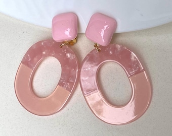 Large clip on blue or pink hoop earrings with tortoiseshell accents.