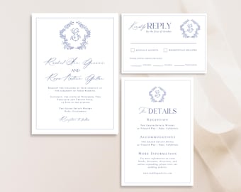 May include: A wedding invitation suite with a blue and white color scheme. The invitation features a floral wreath with a monogram in the center. The text reads "Rachel Ann Greece and Ross Nathan Galler". The RSVP card includes a floral wreath with a monogram and the text "Kindly Reply by the first of October". The details card features a floral wreath with a monogram and the text "The Details".
