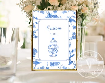 May include: A gold-framed sign with a blue and white floral pattern. The sign says "Custom Sign" and features a blue and white porcelain vase.