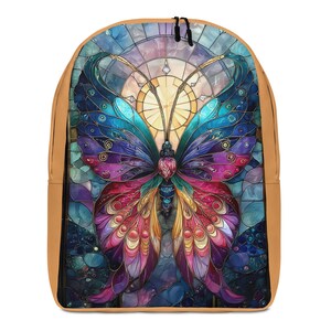 Könnte beinhalten: Ein Rucksack mit einem lebendigen Schmetterlingsmotiv im Buntglas-Stil mit komplexen Mustern in Blau-, Lila-, Rosa- und Goldtönen. Der Schmetterling ist vor einem kreisförmigen hellen Hintergrund zentriert und der Rucksack hat hellbraune Seitenteile.